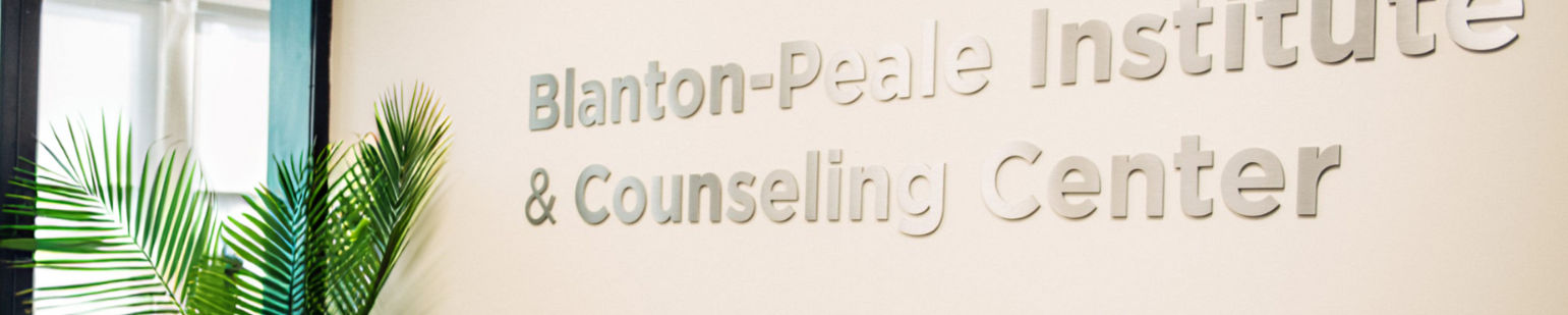 Blanton-Peale Institute and Counseling Center’s name on the reception wall, beside a green plant.